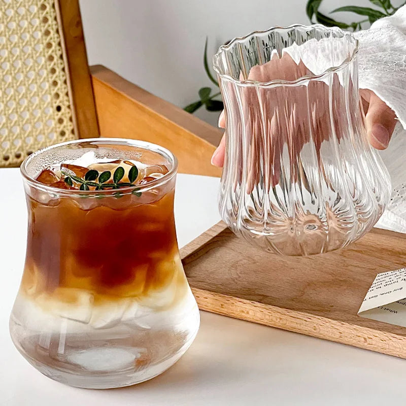 “Vaso de vidrio transparente con diseño ondulado, ideal para café helado, jugo, leche o té.”