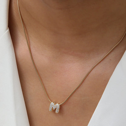 ✨ Collar inicial con letra inglesa, bañado en oro 18K y decorado con circonias incrustadas. Diseño puff/bubble llamativo, moderno y femenino, ideal para destacar tu estilo.