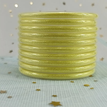 Set de 10 pulseras de silicona con glitter, en tonos cálidos dorados, ideales para complementar cualquier look femenino.