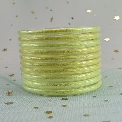 Set de 10 pulseras de silicona con glitter, en tonos cálidos dorados, ideales para complementar cualquier look femenino.