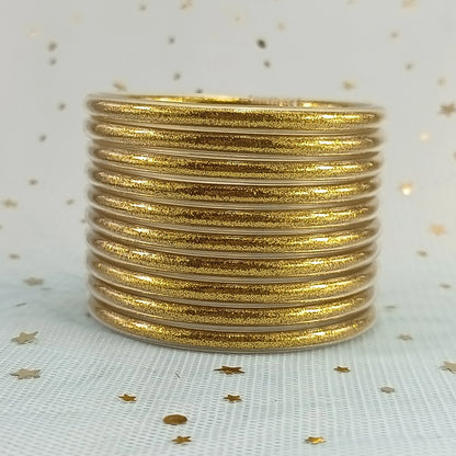 Set de 10 pulseras de silicona con glitter, en tonos cálidos dorados, ideales para complementar cualquier look femenino.